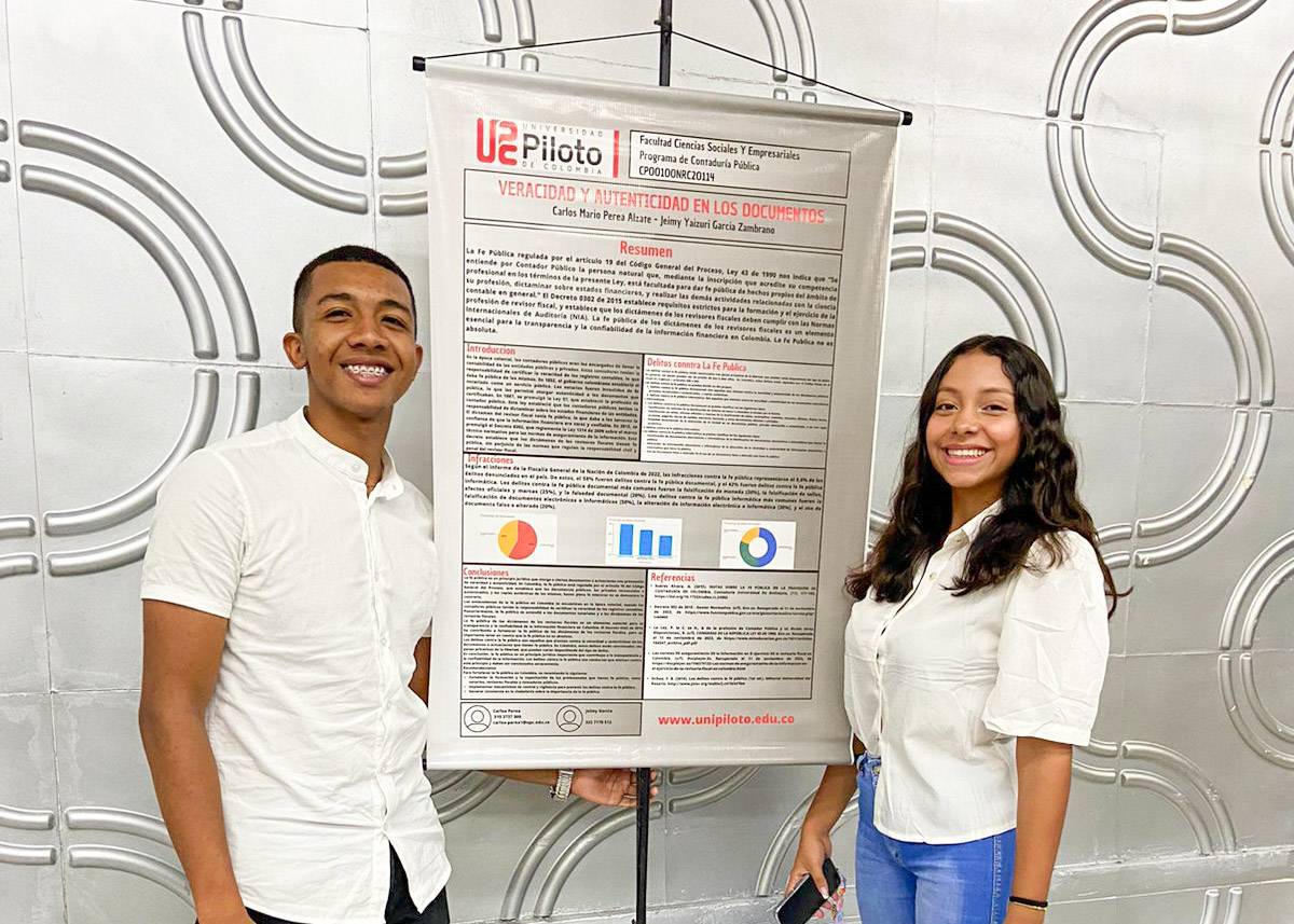 una fotografía con dos estudiantes sonrientes junto a su poster de investigación dirante el tercer encuentro de estudiantes de contaduría pública en Girardot