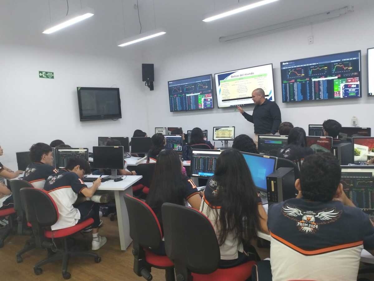 Una fotografía del docente Efraín Granados brindando la capacitación sobre mercádos bursátiles a estudiantes del Colegio Americano, en el Punto Bolsa de Valores de Colombia de la Universidad Piloto.