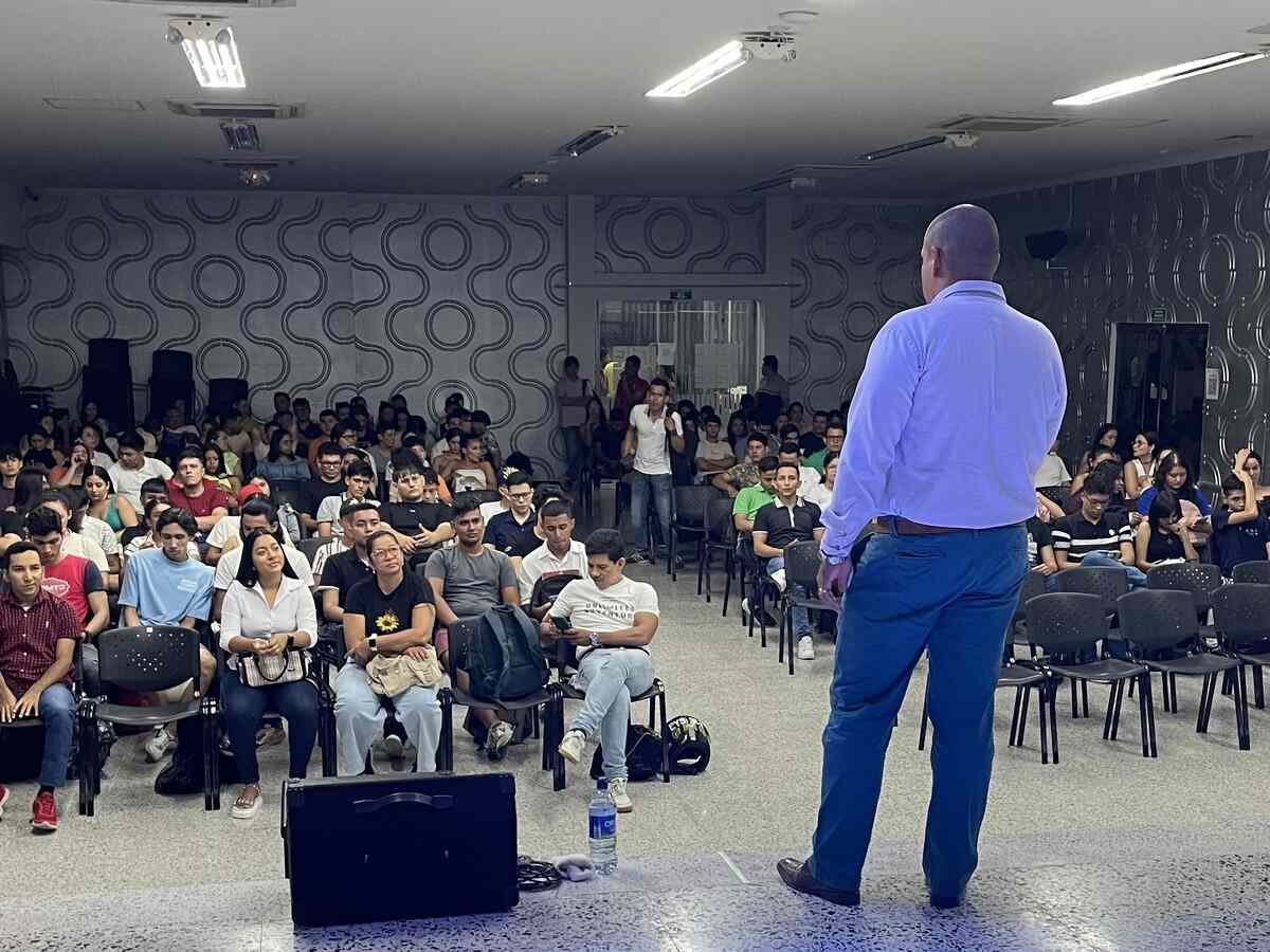Una fotografía que muestra al docente Efrain Granados hablando ante el auditorio lleno durante la Charla de Salud Mental y Liderazgo.