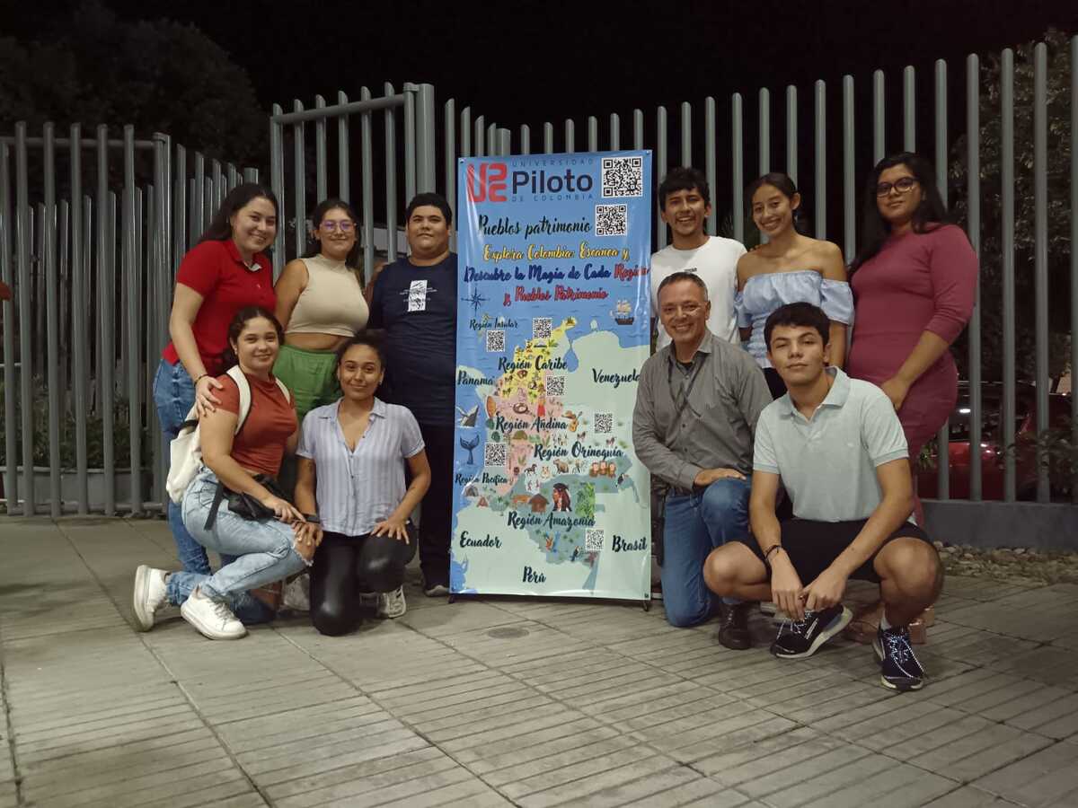 Una foto de estudiantes de administración turística y hotelera junto al mapa interactivo que diseñaron para promover el patrimonio nacional