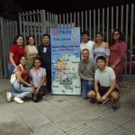 Una foto de estudiantes de administración turística y hotelera junto al mapa interactivo que diseñaron para promover el patrimonio nacional