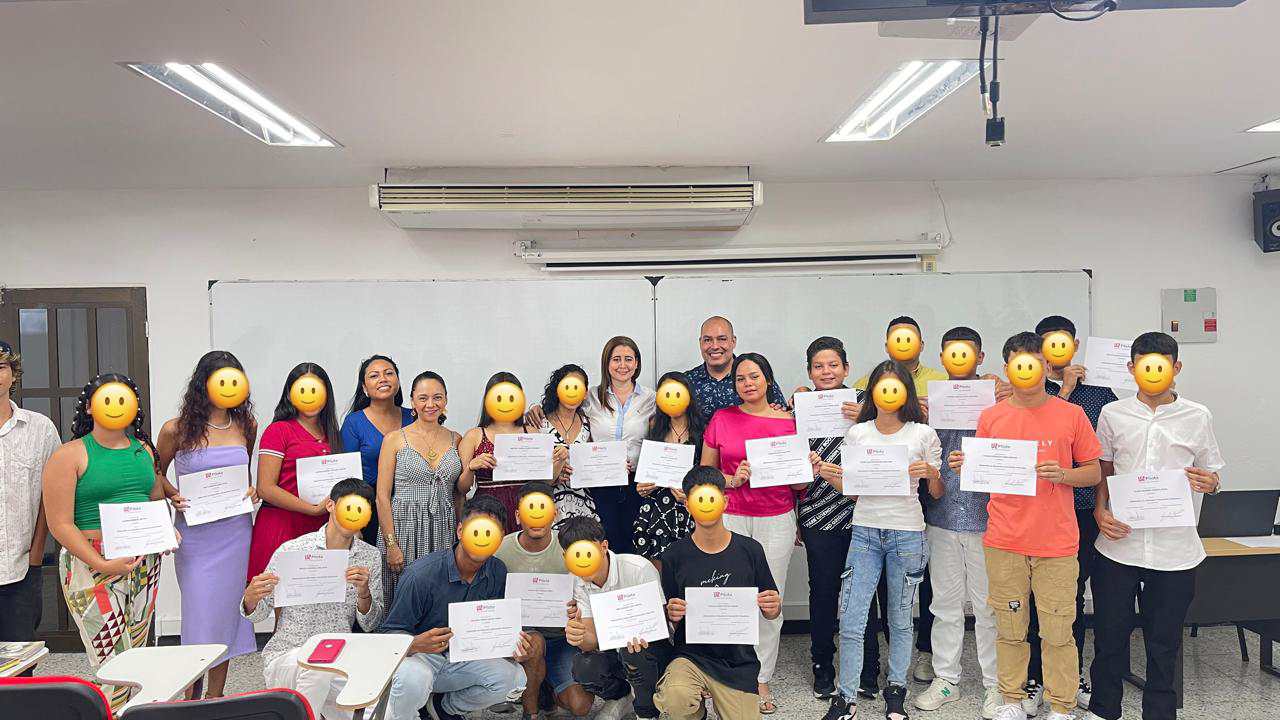 Una fotografía que muestra a los asistentes del curso, son jóvenes sosteniendo sus certificados. Sus rostros están censurados con caras de emoji amarillas para cubrir su identidad.