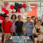 Una fotografía que muestra a un grupo de estudiantes y docentes de la Universidad Piloto de Colombia, Seccional del Alto Magdalena, durante la celebración del Día del Ingeniero 2024. De fondo se ven unos globos festivos y en la mesa que tienen en frente se observa una torta grande con el logo de la Universidad.