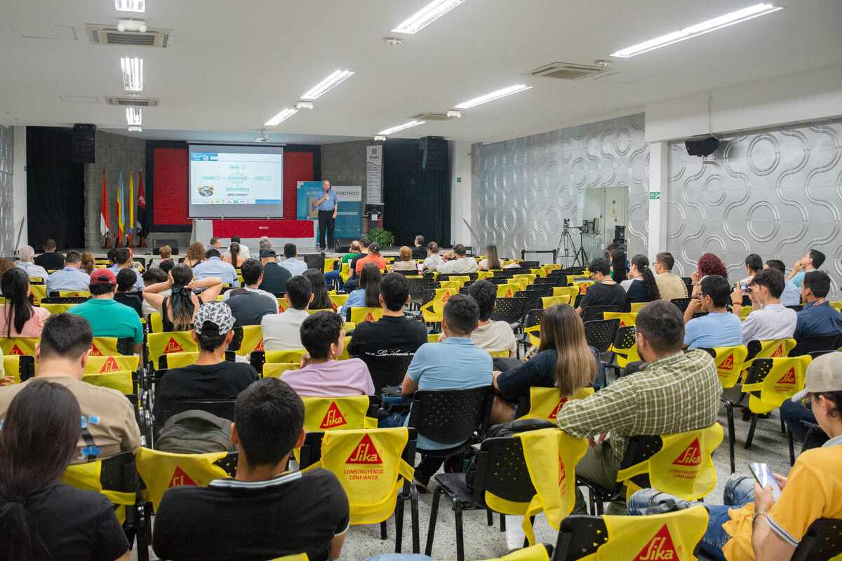 Auditorio lleno de asistentes escuchando una presentación en la 2ª Feria de Construcción de Obras Comunitarias llevada a cabo en la UniPiloto, en Girardot.