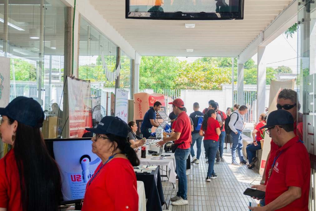 El pasillo de la universidad con personas caminando y disfrutando de la 2ª Feria de Construcción de Obras Comunitarias llevada a cabo en la UniPiloto, en Girardot.