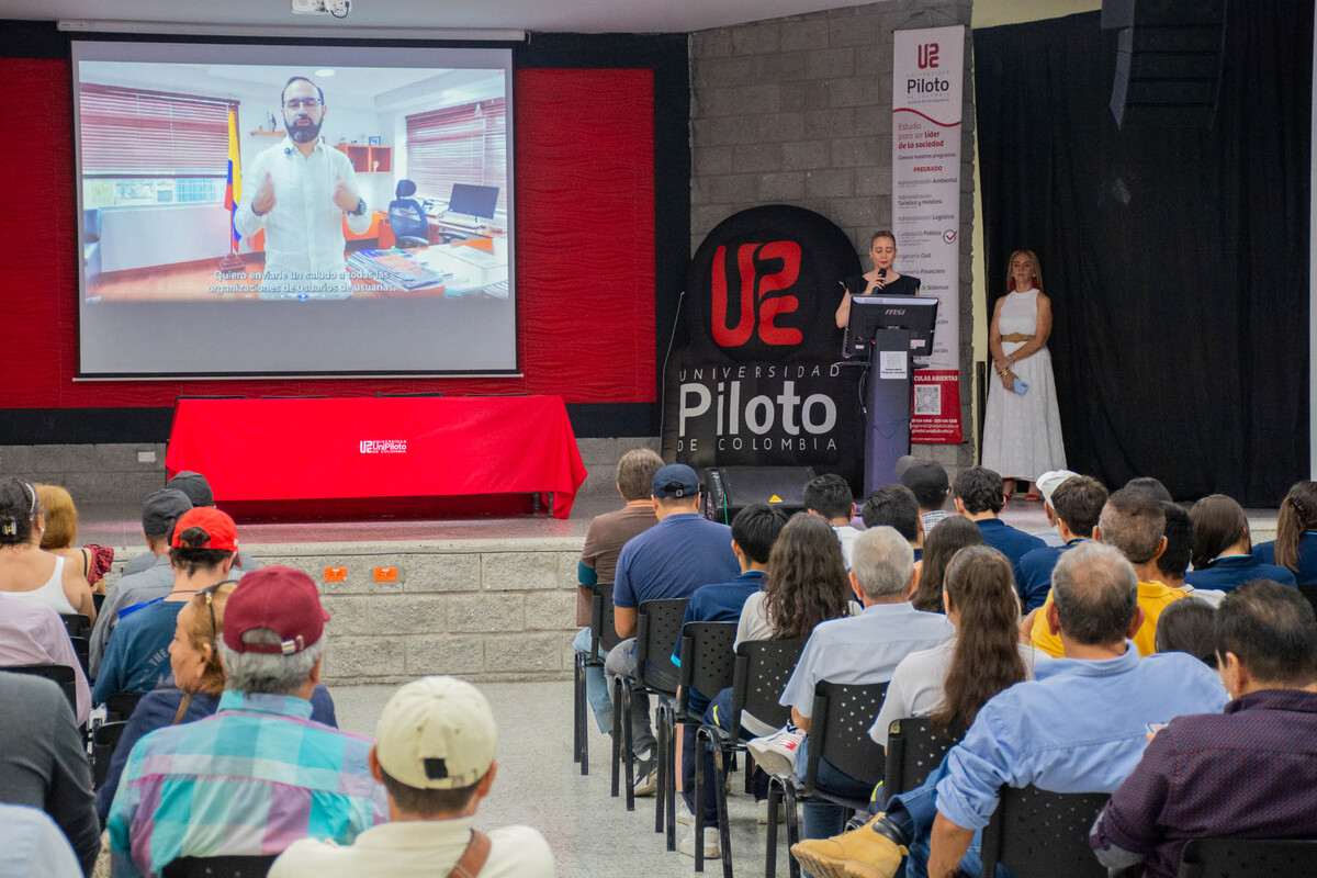 Una fotografía de ceremonia de instalación a la Asamblea Popular por la Democracia Energética y la Paz llevada a cabo en la Universidad Piloto de Colombia, en Girardot. Se observa a la directora académica Lorena Judith Échavez impartiendo unas palabras de bienvenida ante el auditorio, ante decenas de personas sentadas.