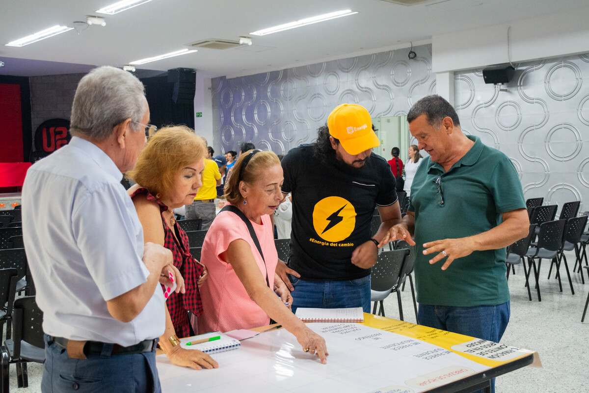 Una fotografía con los asistentes a la Asamblea Popular por la Democracia Energética y la Paz llevada a cabo en la Universidad Piloto de Colombia, en Girardot. Se observan todo en una mesa de trabajo, dialogando.