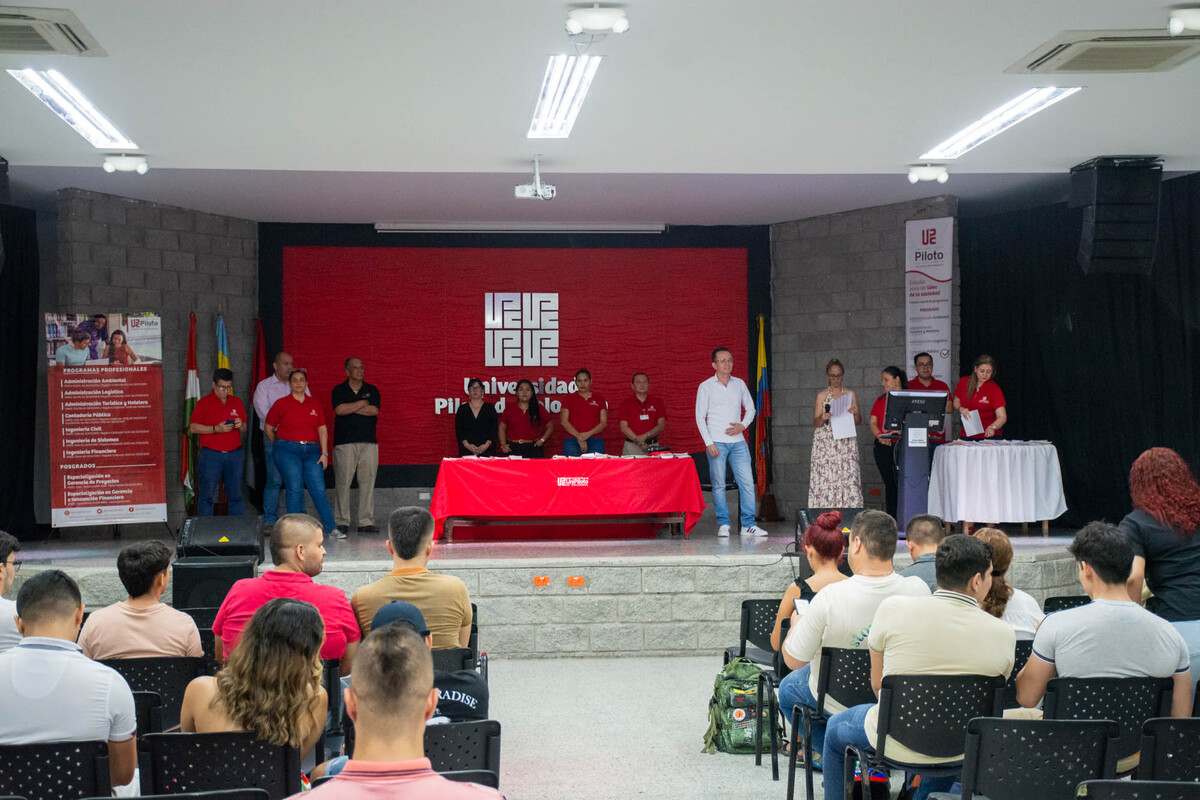 Una foto que muestra a los asistentes de la Ceremonia del Lápiz, en el Auditorio Principal de la Universidad Piloto de Colombia, Seccional del Alto Magdalena, en Girardot. En el estrado se observan los directivos de la universidad, y abajo, los asistentes del evento sentados.