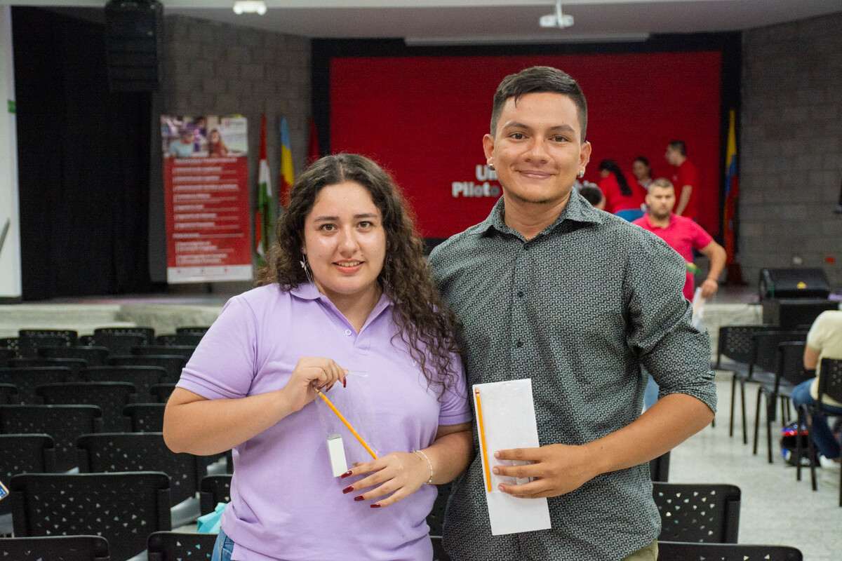 Una foto que muestra a 2 estudiantes asistentes al evento, posando con sus kits del lápiz en las manos. Durante la Ceremonia del Lápiz, en el Auditorio Principal de la Universidad Piloto de Colombia, Seccional del Alto Magdalena, en Girardot.