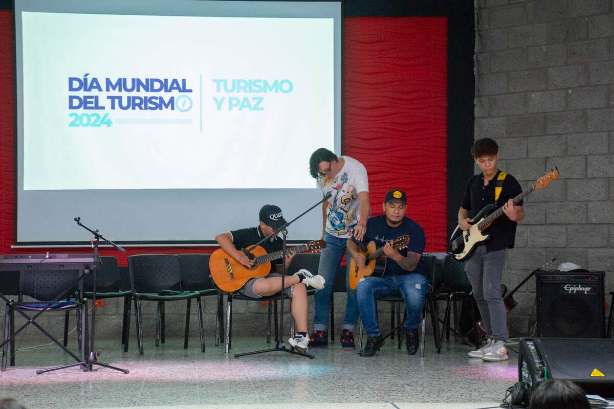 El trío de cuerdas de la casa de la cultura de Girardot durante una presentación de música en vivo el día mundial del turismo 2024 en el auditorio de la Universidad Piloto de Colombia, en Girardot.