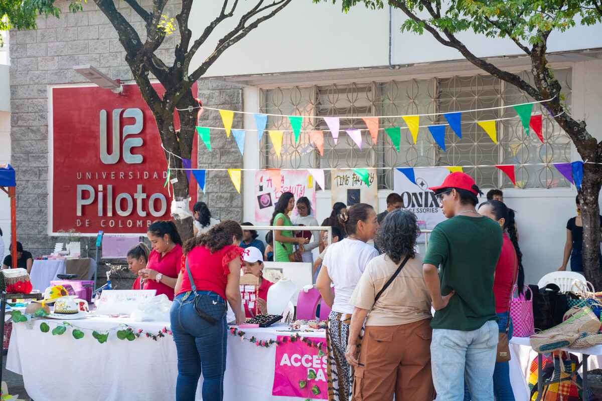 Vista general de la 2.ª Feria Empresarial del Alto Magdalena en la Universidad Piloto de Colombia en Girardot, con carpas y stands de empresarios a lo largo de la calle principal, mientras los asistentes recorren el evento.