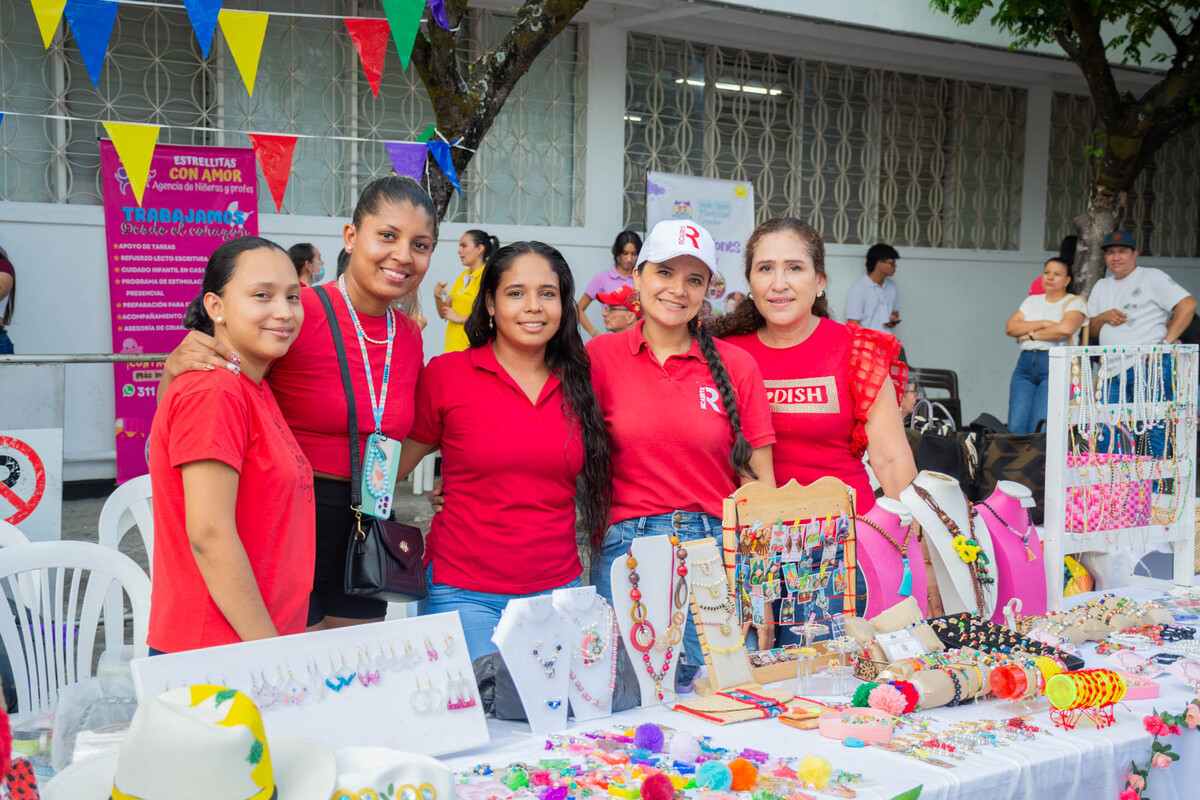 Representantes del emprendimiento “Flashy Accesorios” y estudiantes de la Escuela de Manualidades de Ricaurte posando junto a su stand en la 2.ª Feria Empresarial del Alto Magdalena, organizada por la Universidad Piloto de Colombia en Girardot.