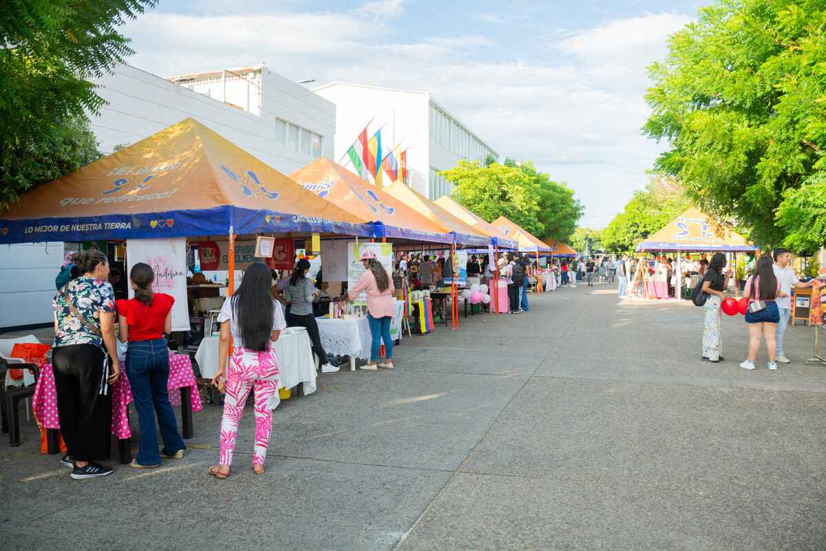 Vista general de la 2.ª Feria Empresarial del Alto Magdalena en la Universidad Piloto de Colombia en Girardot, con carpas y stands de empresarios a lo largo de la calle principal, mientras los asistentes recorren el evento.