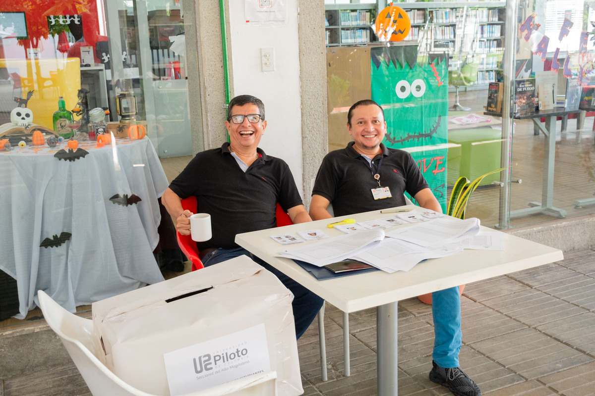 La dupla de jurados junto a la urna en las elecciones de representantes estudiantiles 2024 en la Universidad Piloto de Colombia, en Girardot.