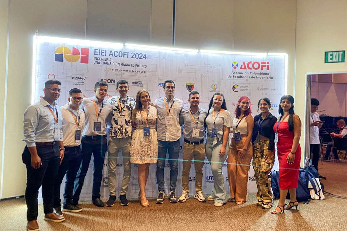 La delegación de la Universidad Piloto de Colombia posando en grupo. En la fotografía se ven estudiantes de la Facultad de Ingenierías y los directivos. De fondo de observa el tablero de patrocinadores del Encuentro Internacional de Educación en Ingeniería 2024.