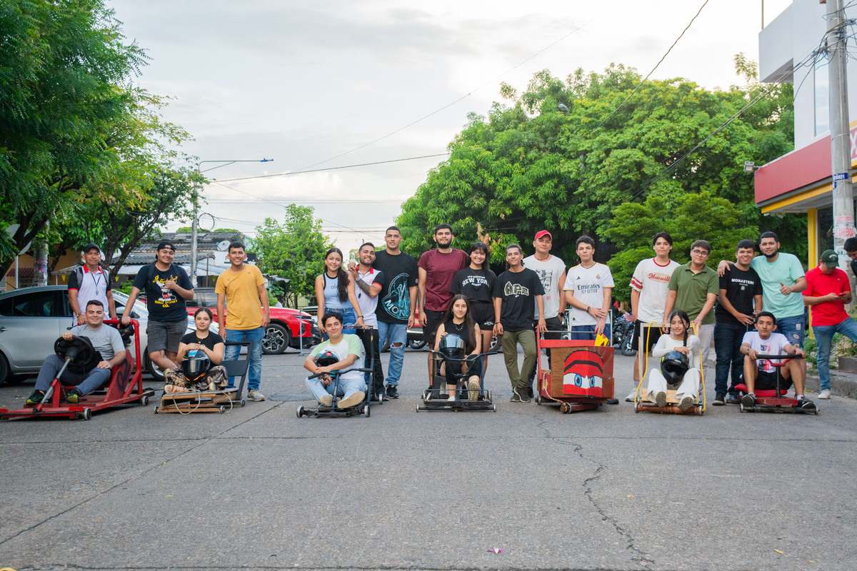 Los equipos de la Carrera de Balineras posan orgullosamente junto a sus carros personalizados después de la competencia en la Semana Universitaria 2024.