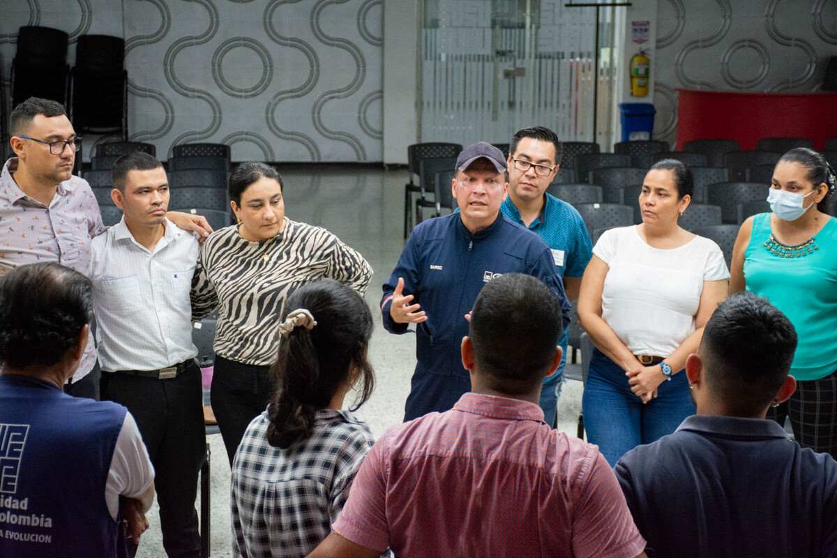 El equipo de Brigadistas de la Universidad Piloto de Colombia, Seccional del Alto Magdalena, durante la fase de preparación antes del simulacro. Están de pie recibiendo instrucciones por el delegado de la ARL AXA Colpatria, quien está dando una charla con recomendaciones y lineamientos.